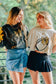 two models wearing gameday football clothes grey women's fleece sweatshirt with  gold bow and football written across in fancy script on the football