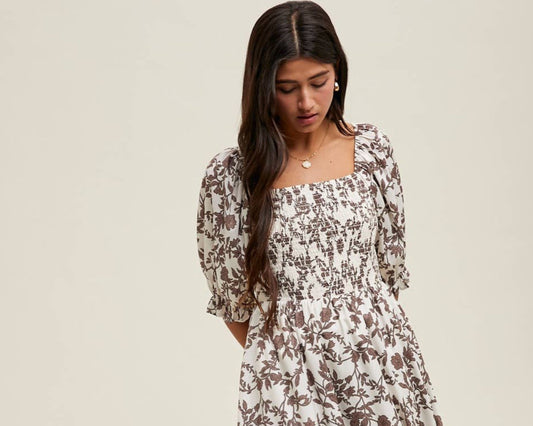 Woman wearing a floral dress against a plain background
